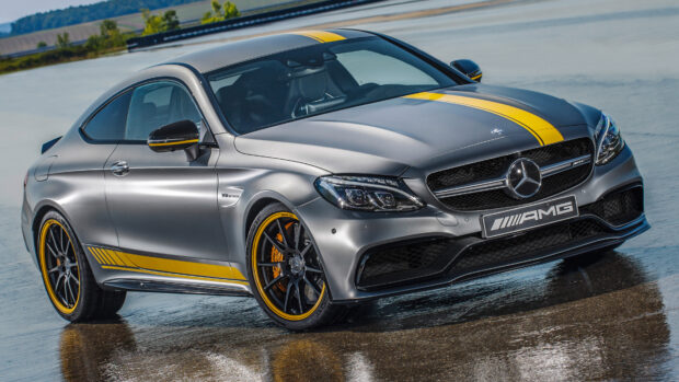A sleek Mercedes Benz sports car with yellow racing stripes on a wet surface