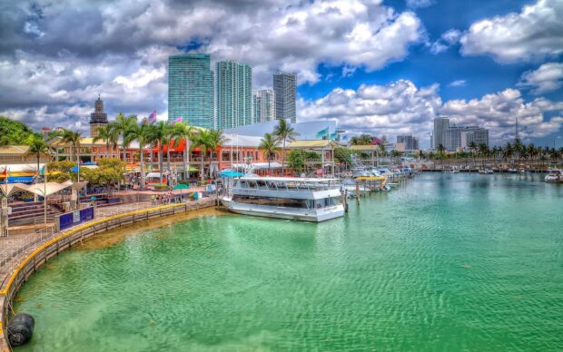 Miami Beach skyline featuring boats and tall buildings under a vibrant partly cloudy sky