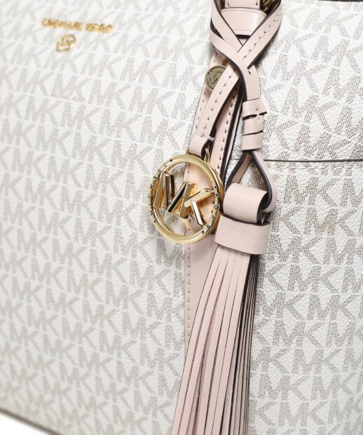 Close up of Michael Kors branded handbag with leather tassel and gold logo charm