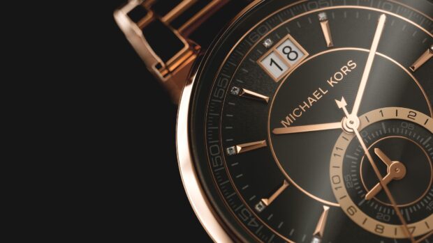 Close up of Michael Kors watch face with rose gold accents and diamonds on a black dial