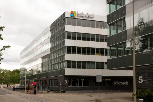 Modern Microsoft building with glass windows and corporate signage on a cloudy day