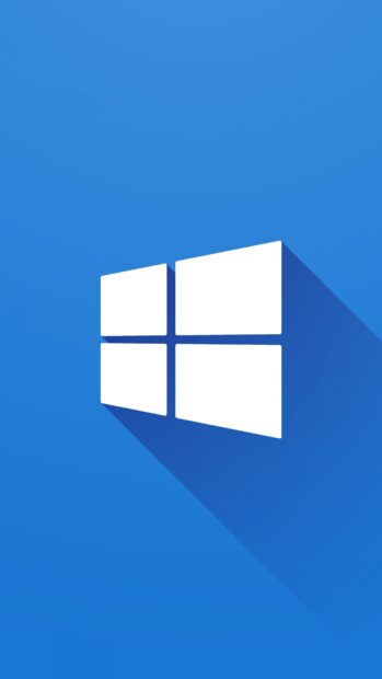 White Microsoft logo with long shadow on blue background showcasing Microsoft