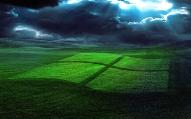Dark clouds over green fields featuring a vivid Microsoft logo shadow on the grass