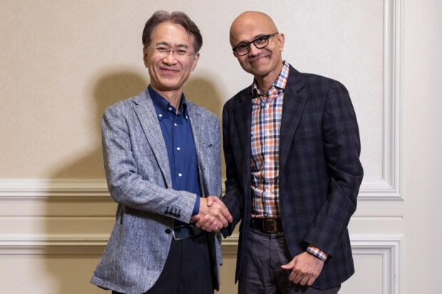 Two businessmen shaking hands in a formal setting representing Microsoft