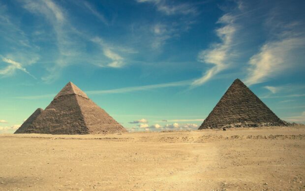 Ancient Middle East pyramids standing under a bright blue sky with wispy clouds