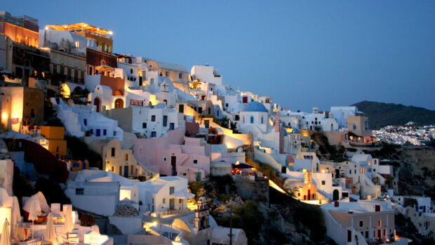 Traditional Middle East architecture on a hillside illuminated at dusk with a clear sky