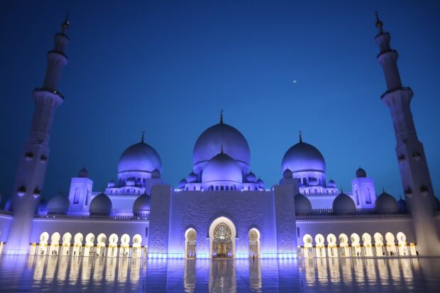 Stunning Middle East mosque architecture illuminated at night under a clear sky
