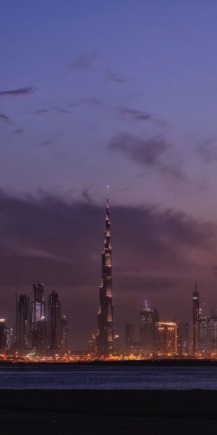 The Dubai cityscape at dusk featuring the Burj Khalifa under a purple sky