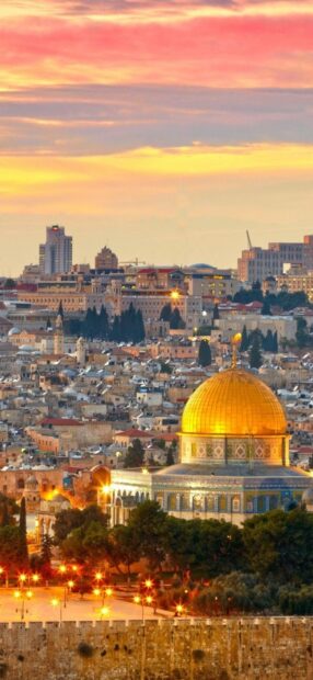 The golden dome of the Middle East cityscape at sunset with vibrant sky colors