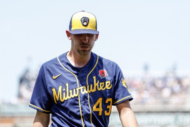 A Milwaukee Brewers player wearing a navy and yellow jersey with number 43 and a matching cap