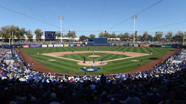 A lively baseball game featuring the Milwaukee Brewers at a packed stadium on a clear sunny day