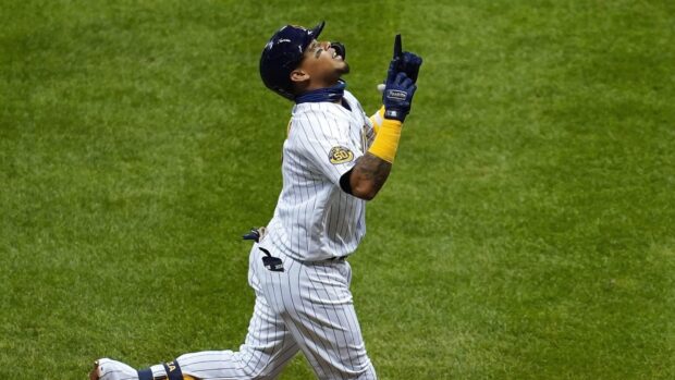 Milwaukee Brewers player celebrates on the field wearing a white pinstripe uniform with a 50th anniversary patch