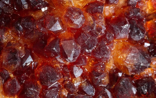 Close up of red minerals with crystalline structures and shiny surfaces