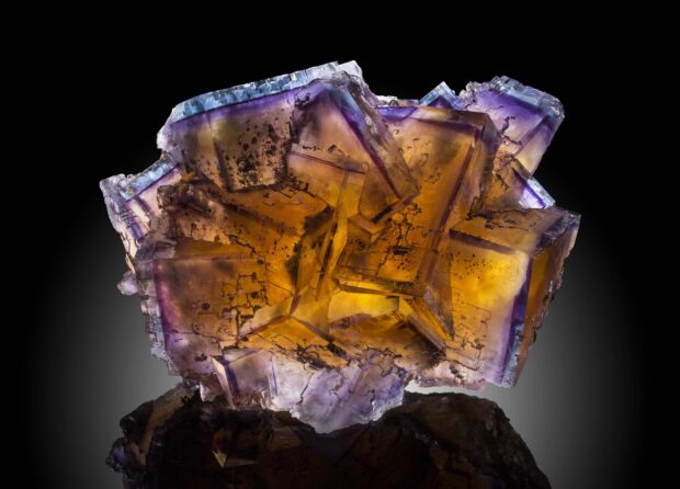 Transparent minerals with purple and amber hues under bright lighting