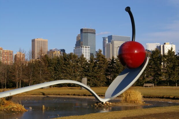 Giant spoon sculpture with cherry in Minneapolis cityscape on a clear day