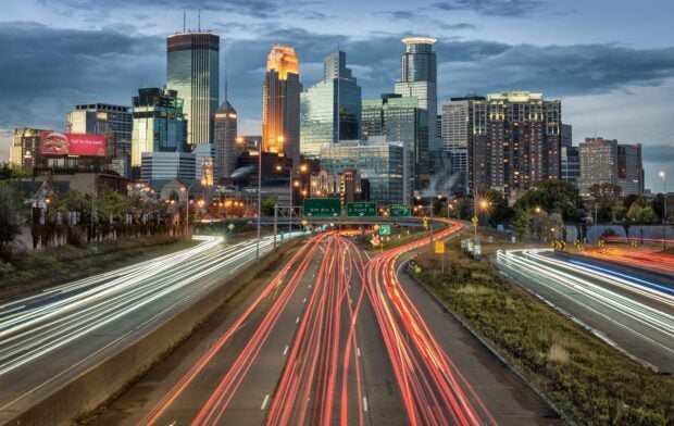 Evening traffic trails in Minneapolis cityscape showing downtown buildings and roads