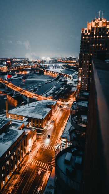 Snow covered streets and bridges in Minneapolis cityscape at night