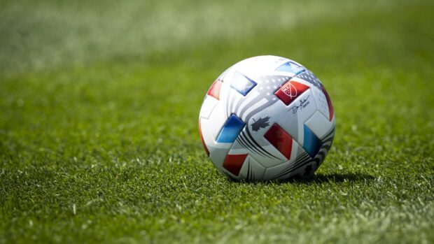 Official Mls ball resting on fresh green grass field
