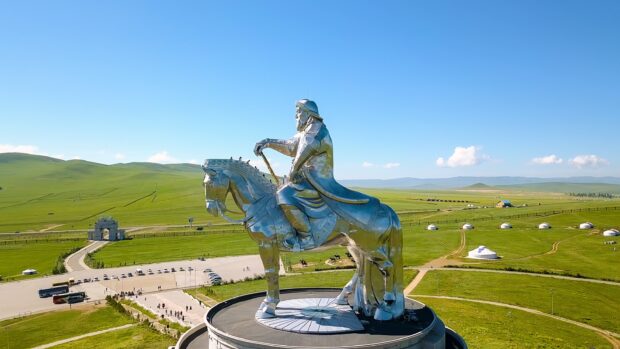 Stainless steel statue of a Mongolian warrior on horseback in vast grassland
