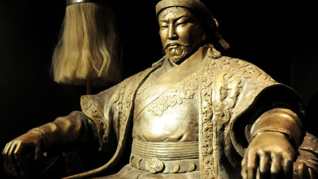 A detailed bronze statue of a Mongolian warrior wearing traditional armor and a headdress