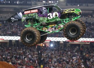 Monster truck Grave Digger jumping high above the crowd at a stadium event