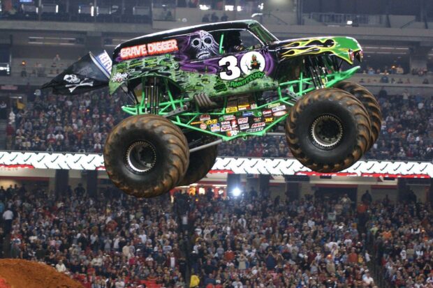Monster truck Grave Digger jumping high above the crowd at a stadium event