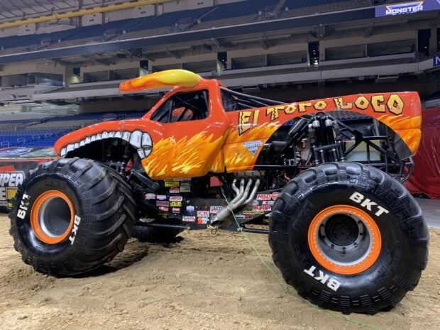 A high quality monster truck with flames and a mouth design on its side