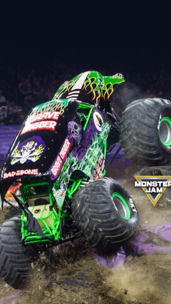 Grave Digger monster truck performing stunts on dirt track at monster jam event