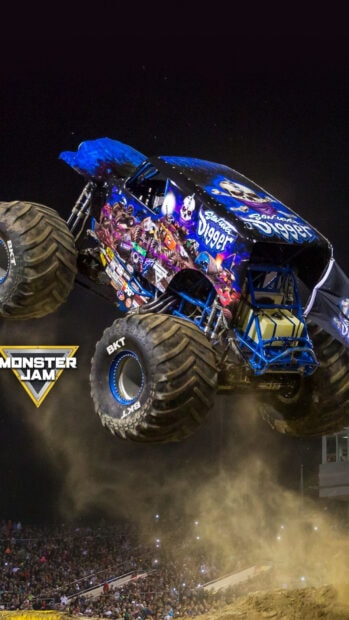 Monster truck Digger performing a high jump stunt at a crowded night event