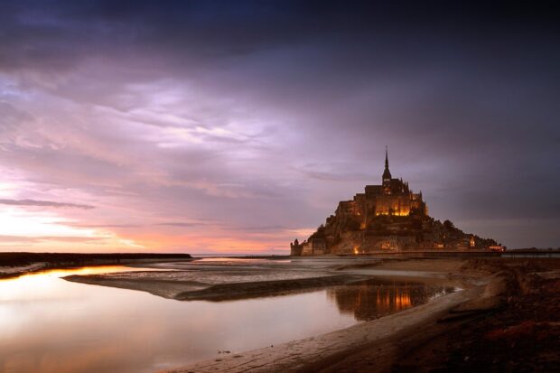Mont Saint Michel during sunset with beautiful sky and water reflection