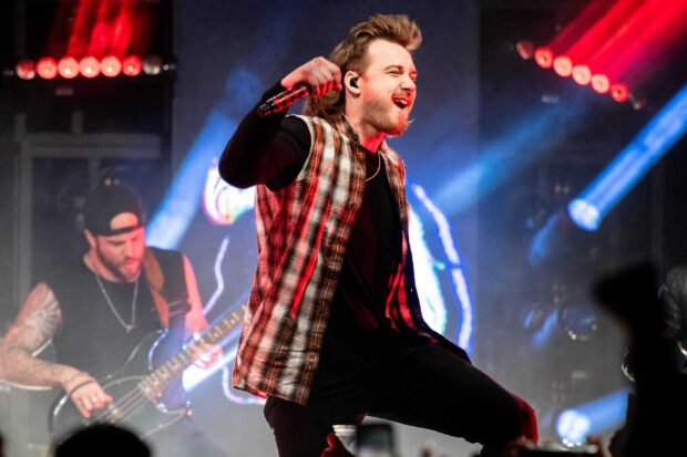 Morgan Wallen performing on stage with a microphone during a concert