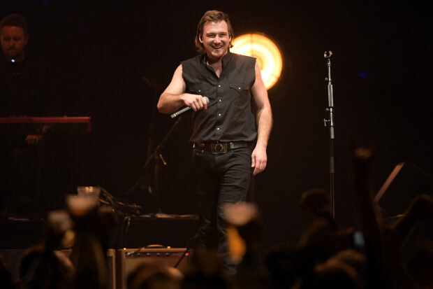 Morgan Wallen smiling on stage during a live music concert