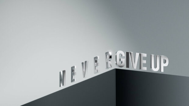 Silver letters forming the phrase never give up on a modern structure with minimalistic design