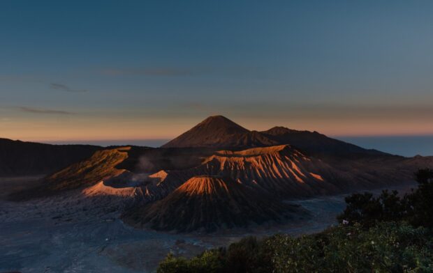 Dramatic volcanic landscape of Mount Bromo during sunrise with clear sky