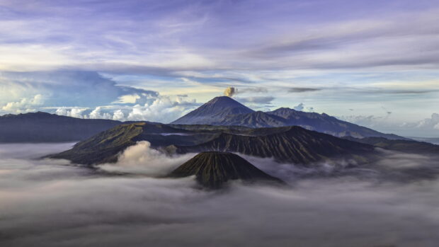 Mount Bromo volcanic landscape with misty clouds and dramatic sky at sunrise