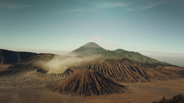 Mount Bromo volcano landscape with mist rising above the rugged terrain