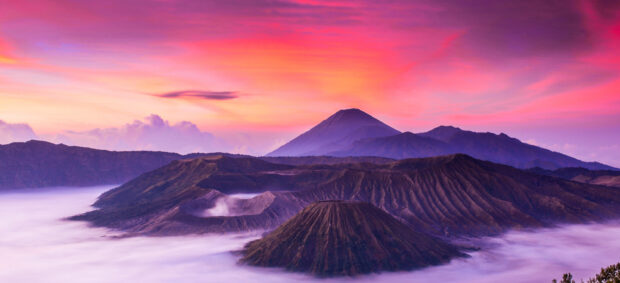 Mount Bromo volcano with mist and colorful sunrise sky in the background