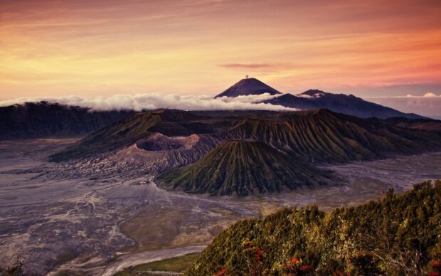 Mount Bromo volcanic landscape with smoke plume and morning light over the mountain range