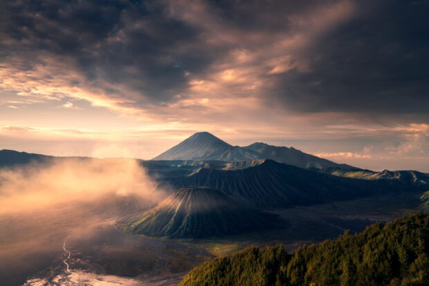 A breathtaking volcanic landscape of Mount Bromo with morning mist and dramatic clouds