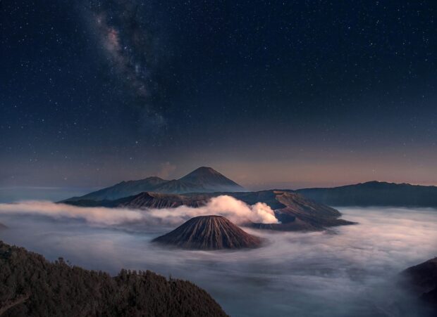 A stunning night view of Mount Bromo with stars and mist surrounding the volcanic landscape