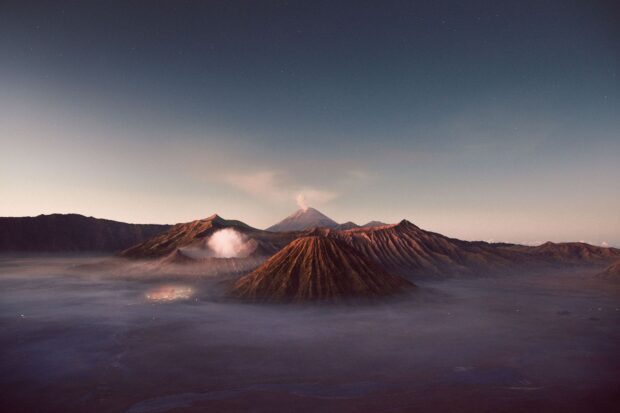 A stunning view of volcanic peaks including Mount Bromo surrounded by morning mist
