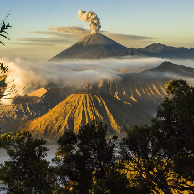 Volcanic landscape with Mount Bromo erupting in the morning light