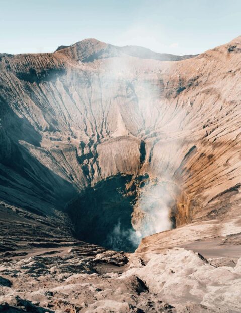 A detailed view of Mount Bromo volcanic crater showing rugged terrain and smoke rising