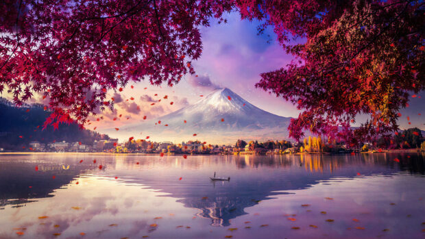 A serene view of Mount Fuji with autumn leaves framing a calm lake and a boat floating in the water