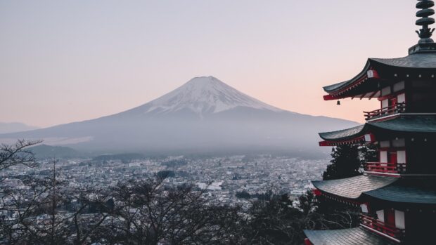 View of Mount Fuji with cityscape and traditional pagoda at sunset