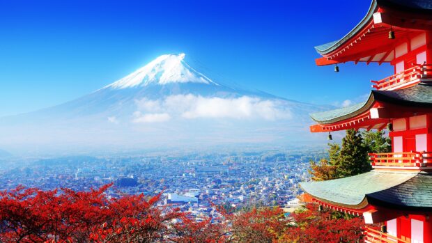 A stunning view of Mount Fuji with vibrant red foliage and a traditional Japanese pagoda in the foreground