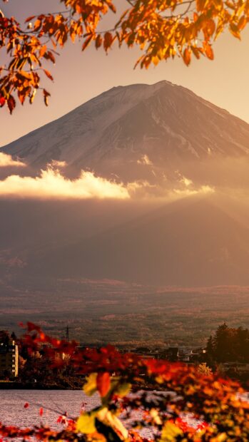 Autumn leaves framing Mount Fuji with clouds and a scenic view