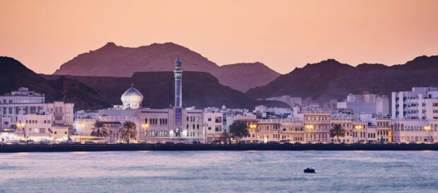 Stunning cityscape of Muscat Oman with mosque and mountains at sunset