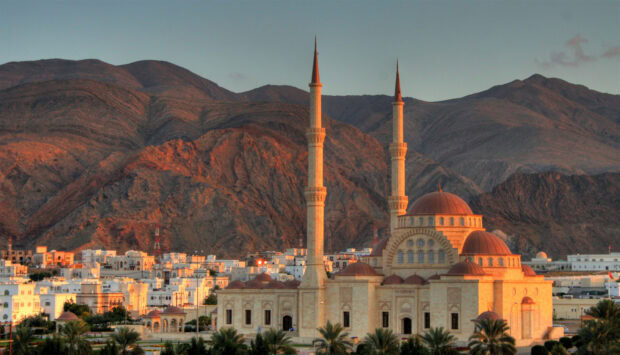 The mosque architecture with mountains in Muscat Oman under warm sunlight