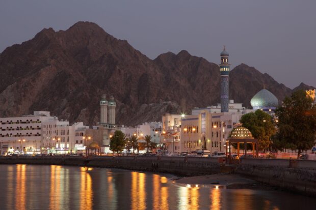 Evening cityscape view of Muscat with mountains and mosque architecture